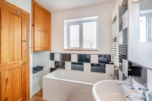 a bathroom with a tub and a sink at 3 Bed in Portinscale oc-w31059 in Portinscale