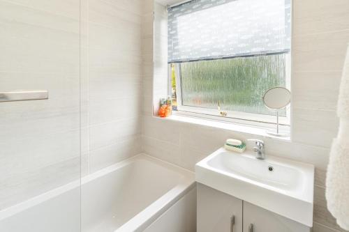 a bathroom with a tub and a sink and a mirror at 2 Bed in Mumbles oc-d32021 in The Mumbles