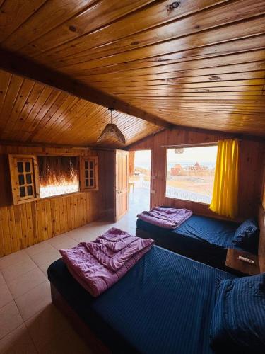 two beds in a room with a wooden ceiling at palma beach camp nuwibae in Nuweiba