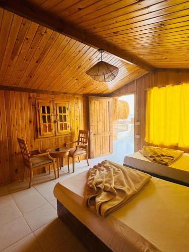 a bedroom with a bed and a table and chairs at palma beach camp nuwibae in Nuweiba