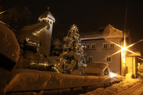 a christmas tree in front of a house with lights at Spisshof in Grins