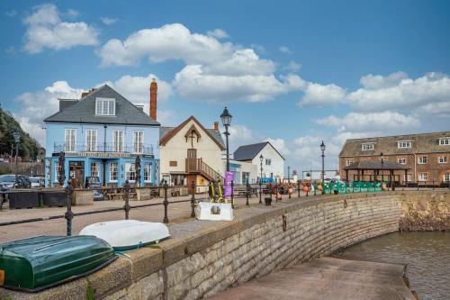 a group of buildings next to a river with boats at Old Ship Aground in Minehead