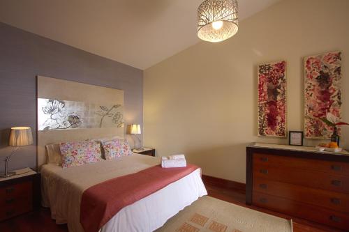 een slaapkamer met een bed, een dressoir en een lamp bij Sunset Sea Breeze in Madalena do Mar