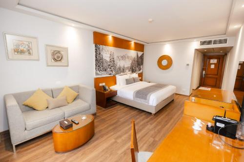 a hotel room with a bed and a couch at Cancun Sokhna Resort & Villas in Ain Sokhna