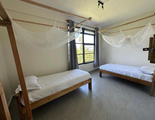 a bedroom with two bunk beds and a window at Kapto Camp in Kapchorwa