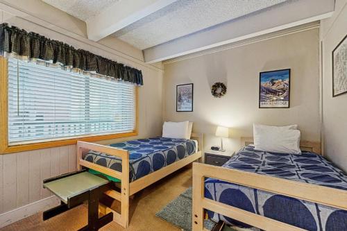 two beds in a room with a window at Ski and Racquet Club Condo in Breckenridge