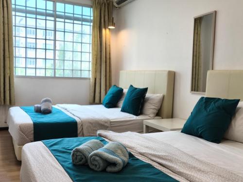 a hotel room with two beds and a window at Eden 8pax 3Rooms apartment near Kuching Airport in Kuching