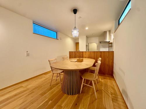 a dining room with a wooden table and chairs at Villa Monica Premium in Nagoya
