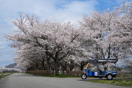 a small vehicle parked on a road next to trees at HOTEL Reise Basis ホテルライゼベイシス Kakunodate in Akita in Senboku