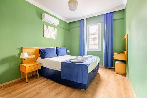 a bedroom with a bed with blue and green walls at Nehir Apart Hotel in Fethiye