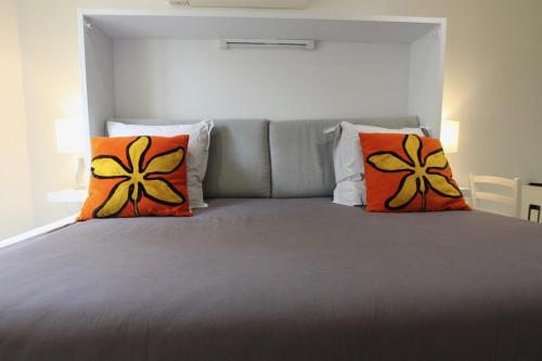 a bedroom with a large bed with orange pillows at Rempart du Chateau-SV82 StudioVincennes in Vincennes