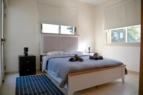 a bedroom with a bed with two stuffed animals on it at Sorelia Latchi Villas 1- Merope Irena in Polis Chrysochous