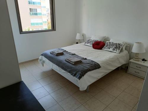 a bedroom with a bed with two pillows and a window at sitbonim in Netanya