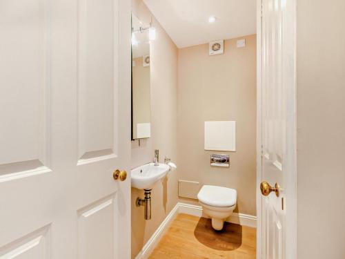 a white bathroom with a toilet and a sink at 2 Bed in Broadway oc-28985 in Broadway