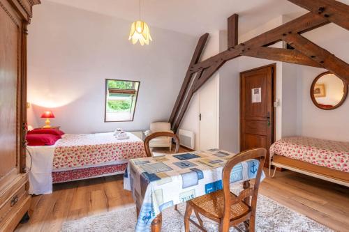a bedroom with two beds and a table and chairs at Chambres d'hôtes ''La Grand' Maison'' in Escalles