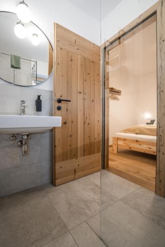 ein Badezimmer mit Waschbecken und Glastür in der Unterkunft Weidenchalets in Sellrain