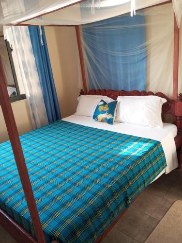 a bed in a room with a canopy bed at Milly's apartment in Malindi
