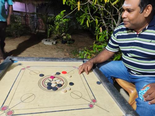 a man playing a board game on a table at S P Restaurant in Kallady