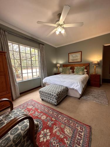 a bedroom with a bed and a ceiling fan at Roosters Nest BnB in Midrand
