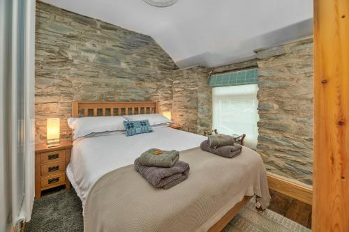 a bedroom with a bed and a stone wall at Finest Retreats - Garreg Ddu in Blaenau-Ffestiniog