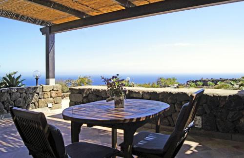 a table and chairs on a patio with the ocean at I Dammusi di Punta Karace in Tracino
