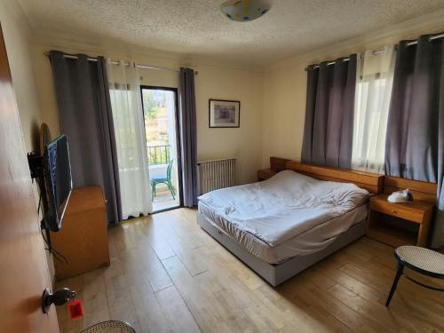 a bedroom with a bed and a tv in it at HighLand Hotel in Aley