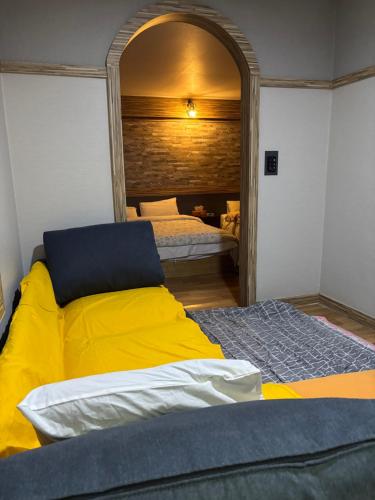 a bedroom with a yellow bed and a mirror at Hotelharu in Eumseong