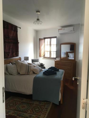 a bedroom with a bed and a dresser and a mirror at Maresia in Sines