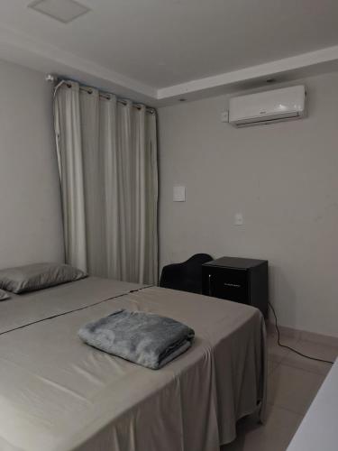 a bedroom with a bed with a towel on it at Pousada Horbis in Guarabira