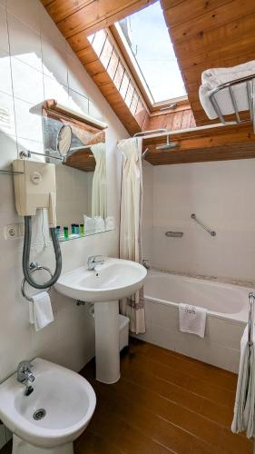ein Badezimmer mit Waschbecken, Toilette und Badewanne in der Unterkunft Alojamientos Cenera in Cenera