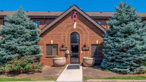 a brick building with two trees in front of it at Studio 6 Extended stay Indianapolis, IN - North Carmel in Carmel