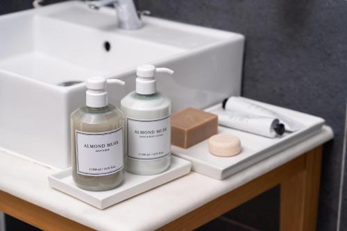 a bathroom counter with two bottles of soap and a sink at White Suites Resort- Adults Only Hotel in Afitos