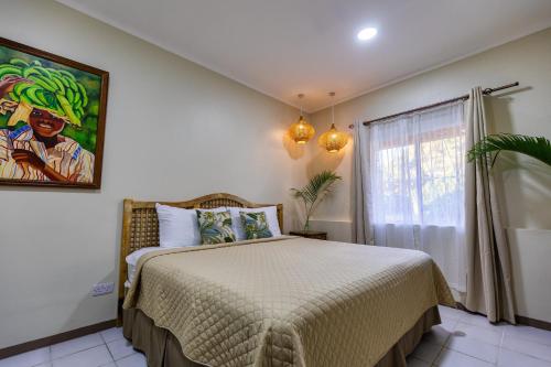 a bedroom with a bed and a painting on the wall at Paradise Beach Hotel in Kingstown