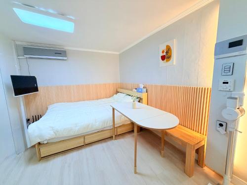 a small bedroom with a bed and a table at Cozy Studio Cheonho in Seoul
