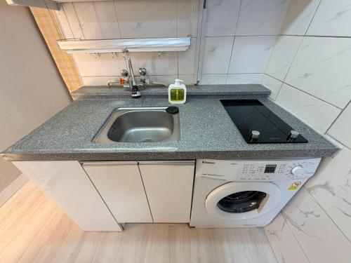 a kitchen with a sink and a washing machine at Cozy Studio Cheonho in Seoul