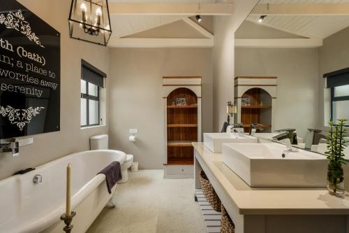 a bathroom with two sinks and a bath tub at Inverell Station by The Oyster Collection in Kenton on Sea