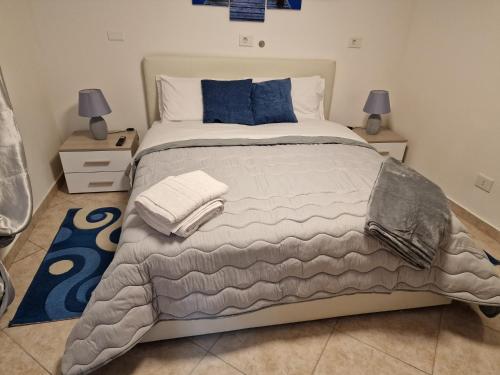 a bedroom with a large bed with blue pillows at Vicolo Stretto Guest House Centro storico in Vibo Valentia