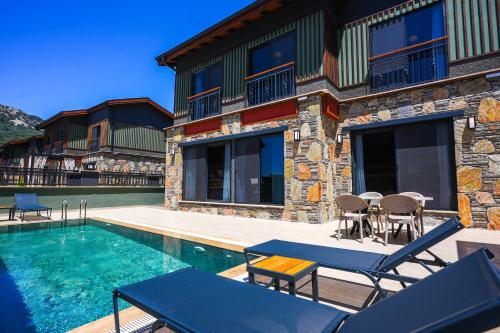 a house with a swimming pool next to a building at champion villas in Ortaca