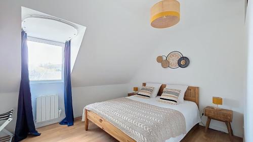 a bedroom with a bed with blue curtains and a window at Escapade à Blainville-Crevon in Blainville-Crevon