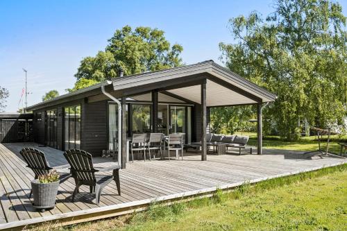 a gazebo with chairs and tables on a wooden deck at Sommerhus tæt på strand i Købingsmark ved Nordborg in Nordborg
