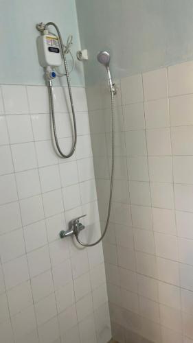 a shower in a bathroom with a hose on the wall at La Petite Maison in Antsiranana