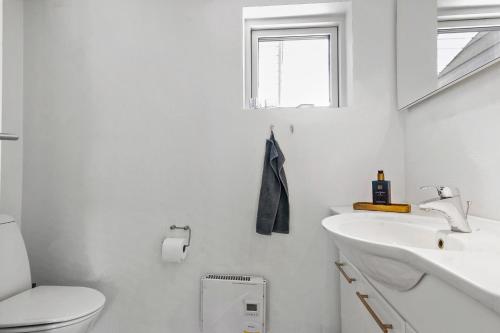 a white bathroom with a toilet and a sink at Sommerhus tæt på strand i Købingsmark ved Nordborg in Nordborg