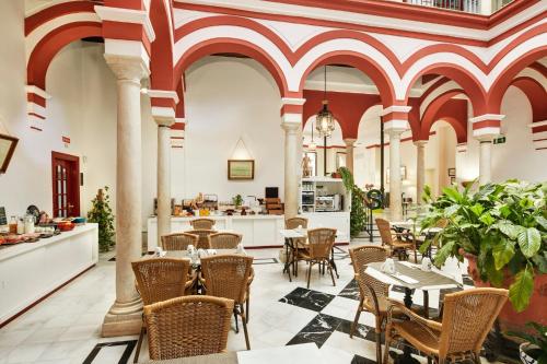 a restaurant with tables and chairs and a bar at Sercotel Las Casas de los Mercaderes in Seville