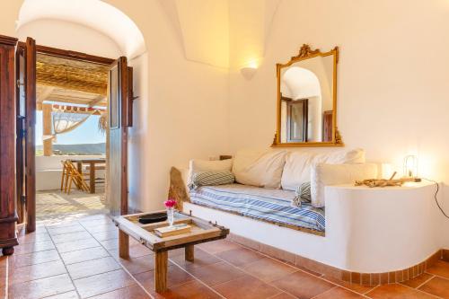 a living room with a couch and a mirror at Dammuso del Nonno in Pantelleria