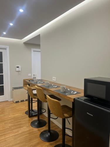 a room with a table with chairs and a flat screen tv at Olympic Lodge in Milan