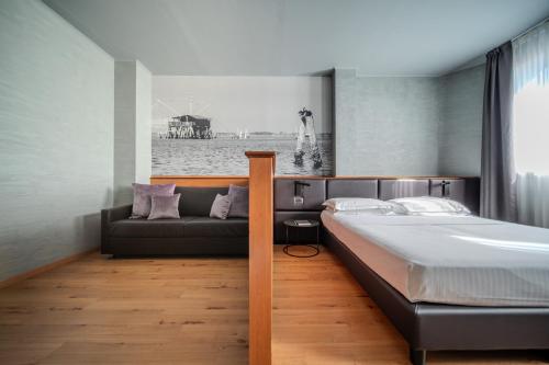 a bedroom with a bed and a couch at Point Hotel in Piove di Sacco