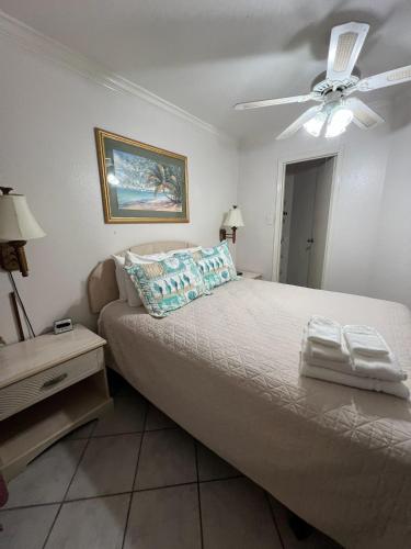 a bedroom with a bed and a ceiling fan at Ocean View - Hot Tubs - Heated Pool - Gym - Tennis ct - Shoreline Stays 22 in Galveston