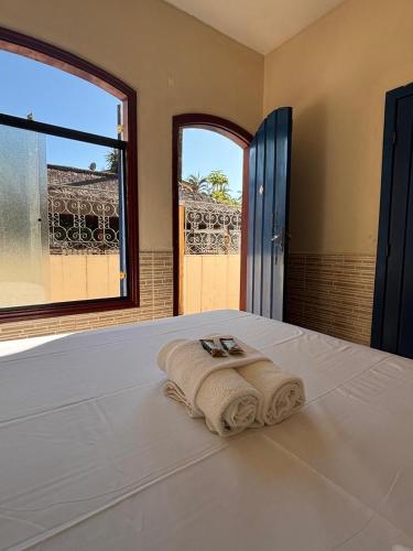 a bedroom with a bed with a towel on it at Pousada Lua Clara in Paraty