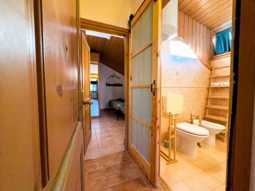 a small bathroom with a toilet and a sink at Begar Nest - ski slope front and panoramic in Sappada