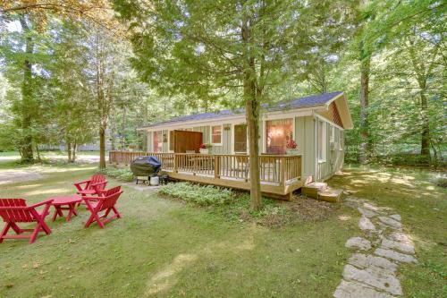 a tiny house in the woods with red picnic tables at Pine Cottage Duplex with Deck Walk to State Park! in Ephraim